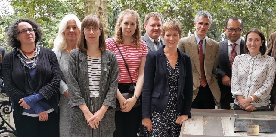 Landscape photo of research team outside with grey table 